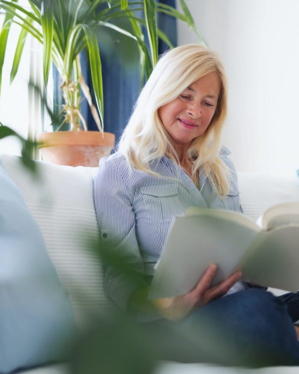 Senior woman reading book after retina surgery